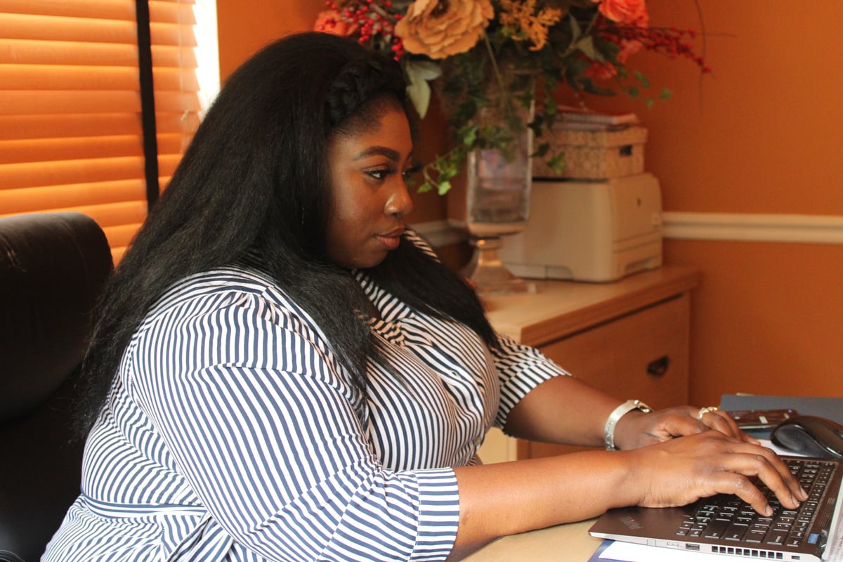 Woman Sitting in Office Typing in Laptop 